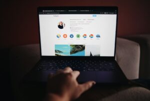 Une personne assise sur un canapé utilisant un ordinateur portable