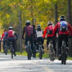 Cyclistes en mouvement sur une route forestière, casques et vêtements colorés visibles
