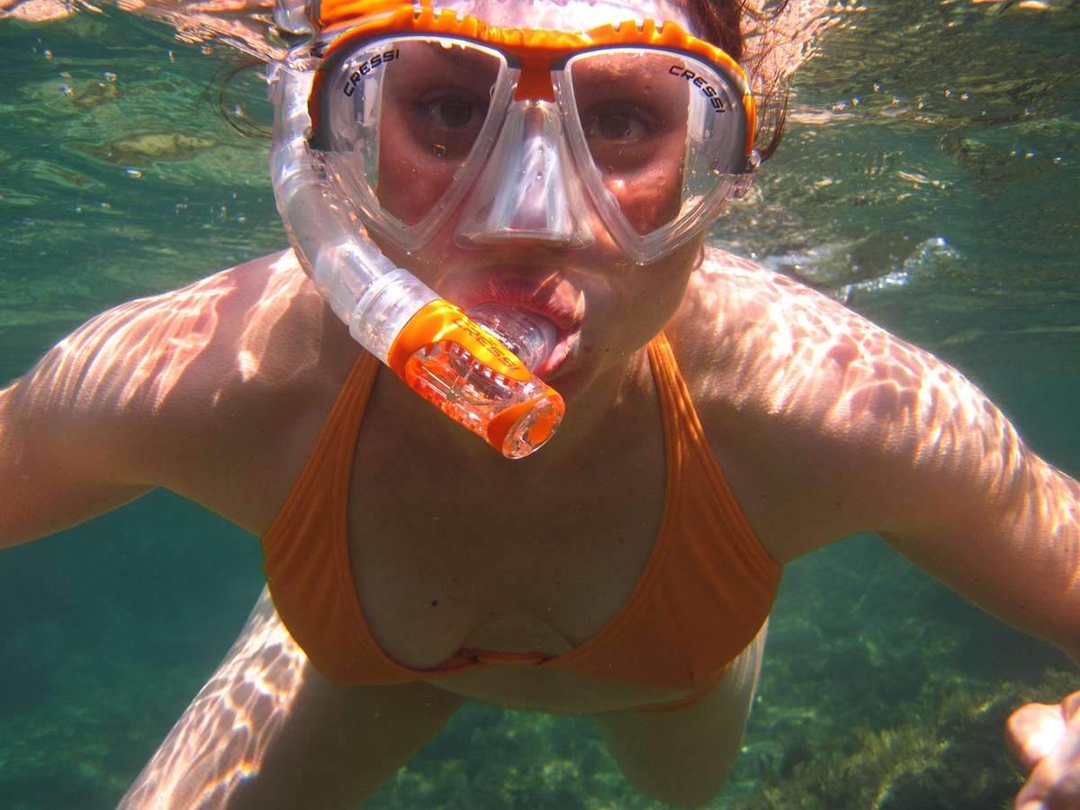 Femme en plongée avec tuba sous l'eau, visage visible